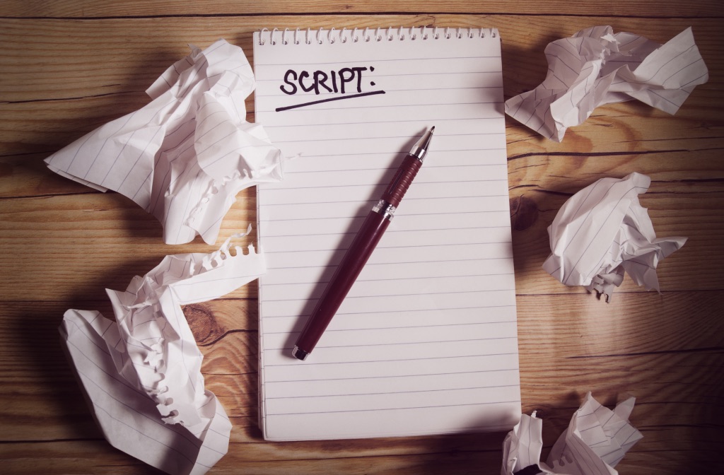 Bloco de anotações com a palavra Script, cercado de papéis amassados